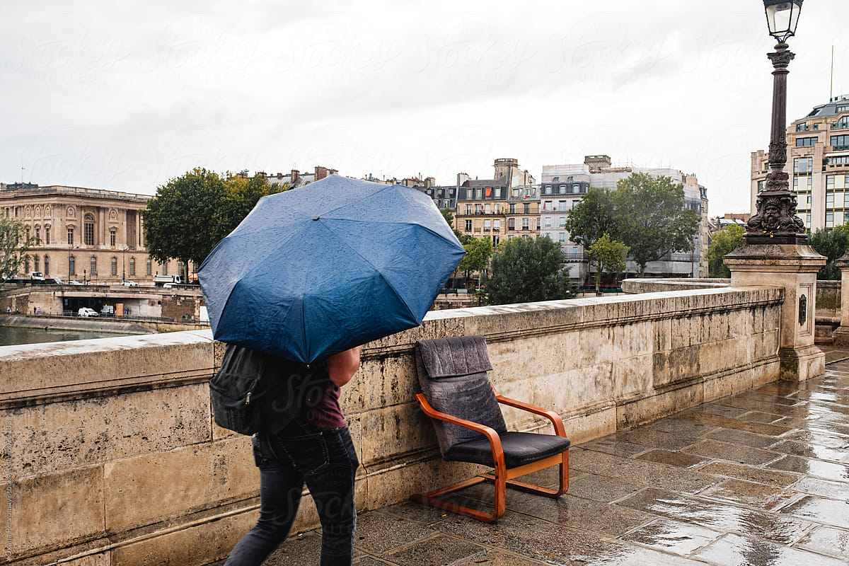 A passerby on a bridge in Paris.
