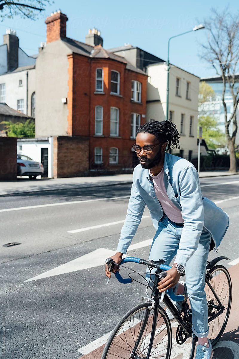 Young black Man Cyclin in Town