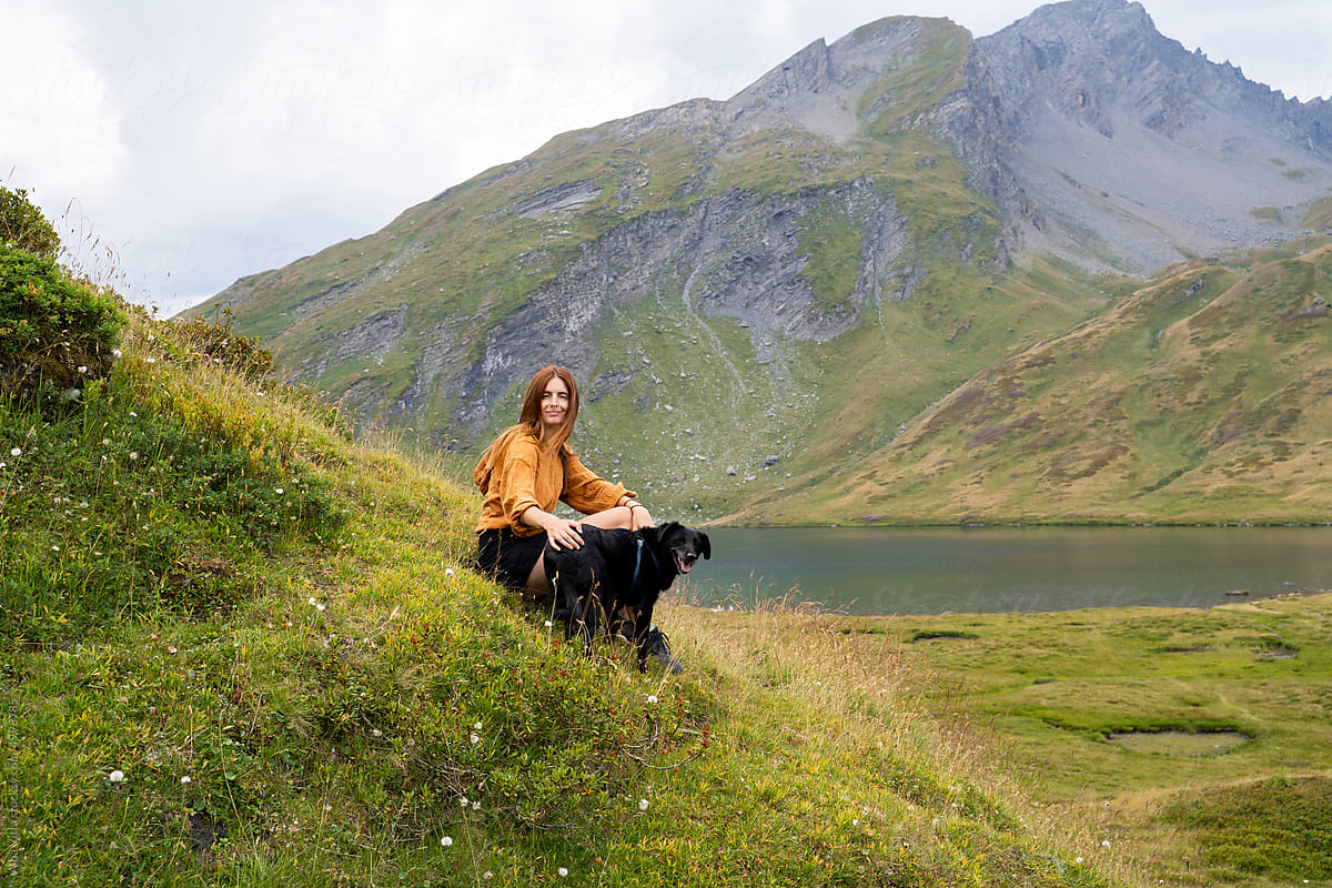 woman with dog in the mountain lake