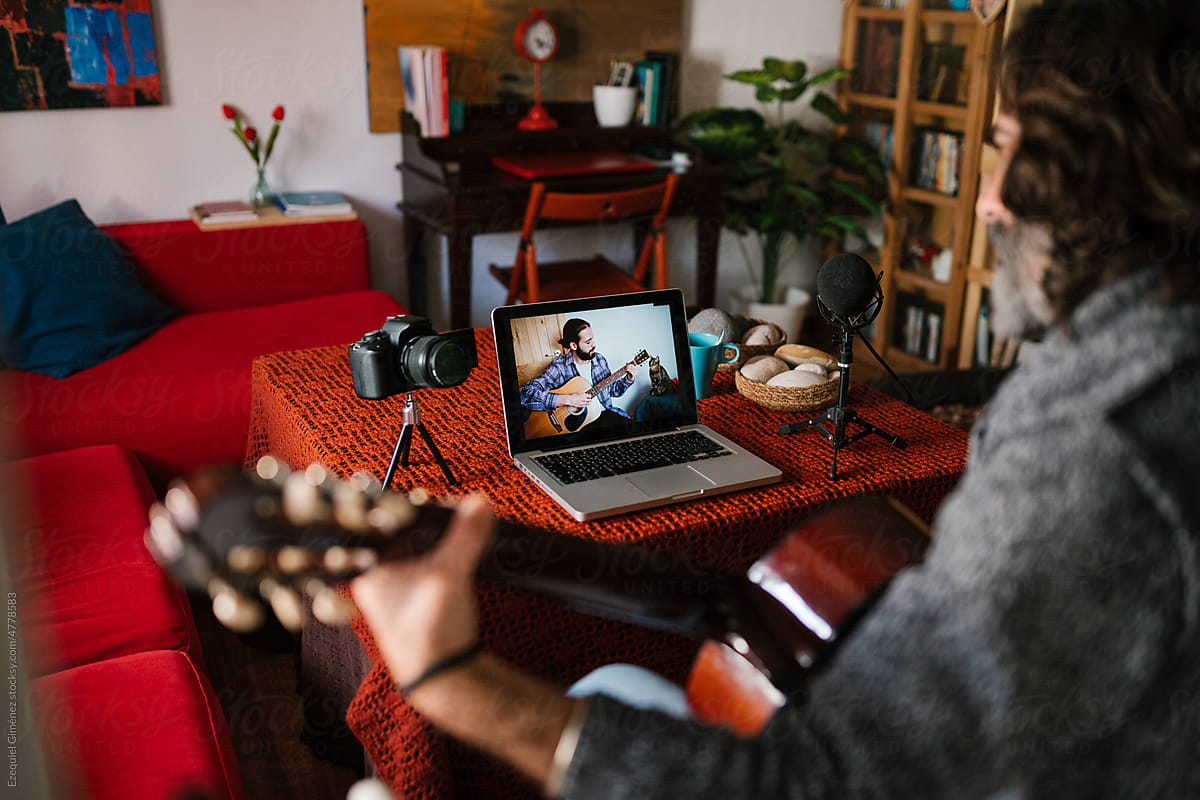 Musician watching online student playing guitar