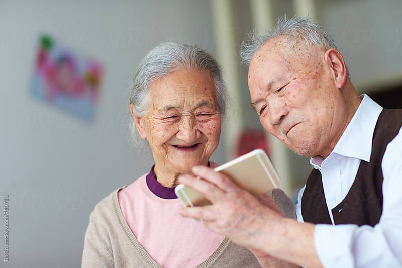 senior asian couple using smart phone indoor