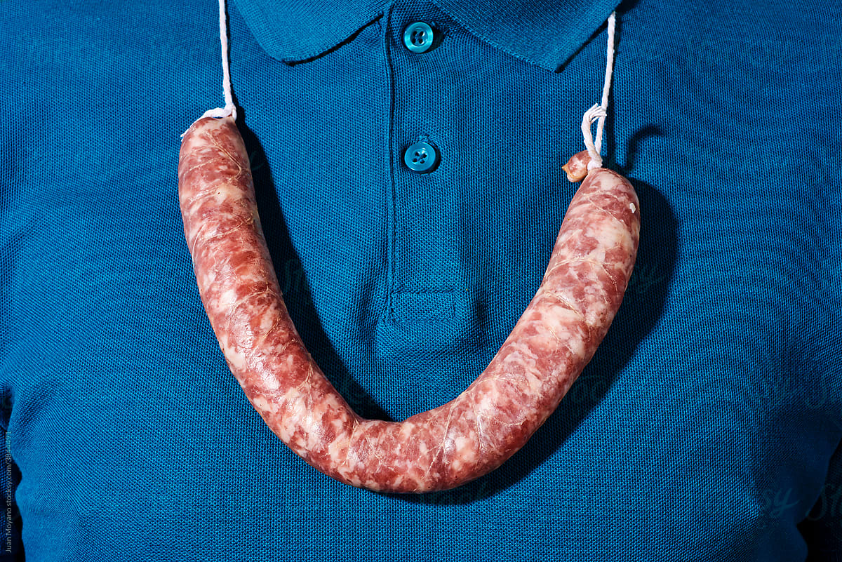 man wears a raw sausage as a necklace