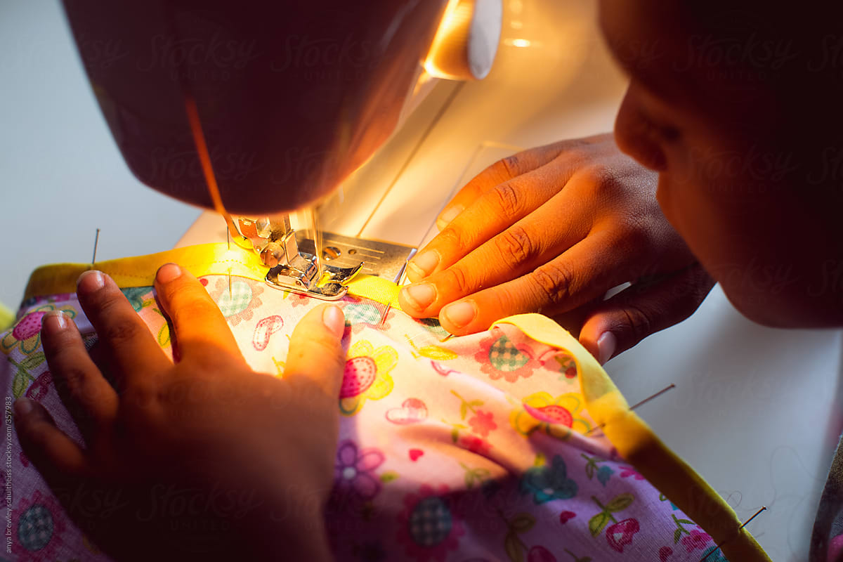 A young child using a sewing machine