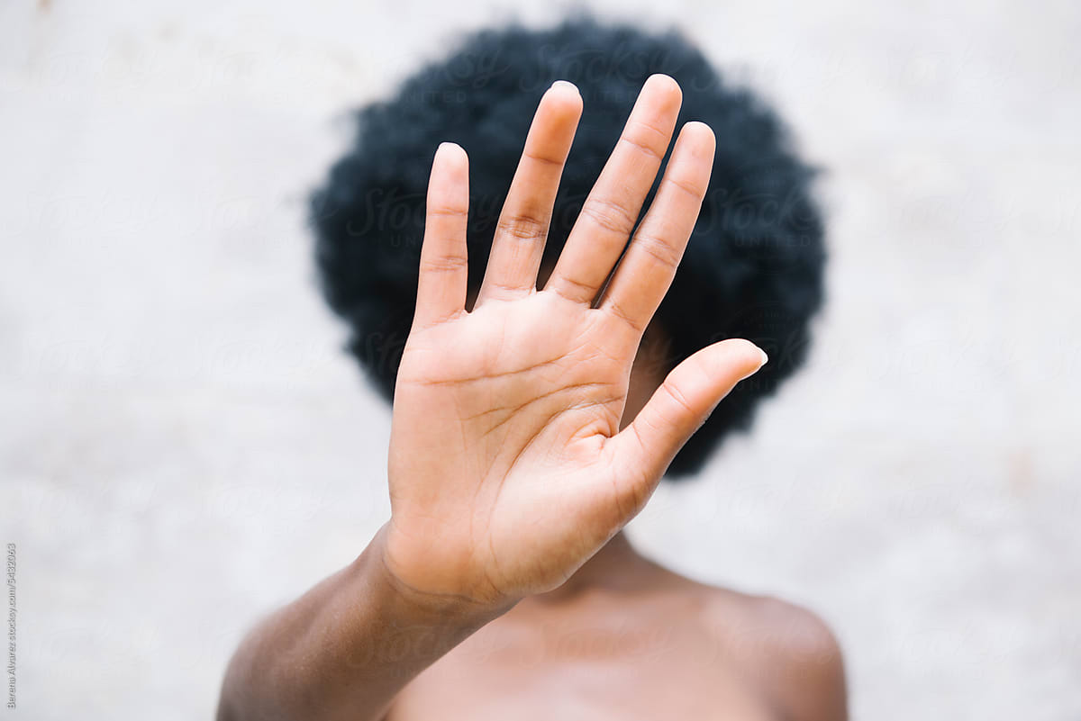 Afro girl holding hand in front of her face