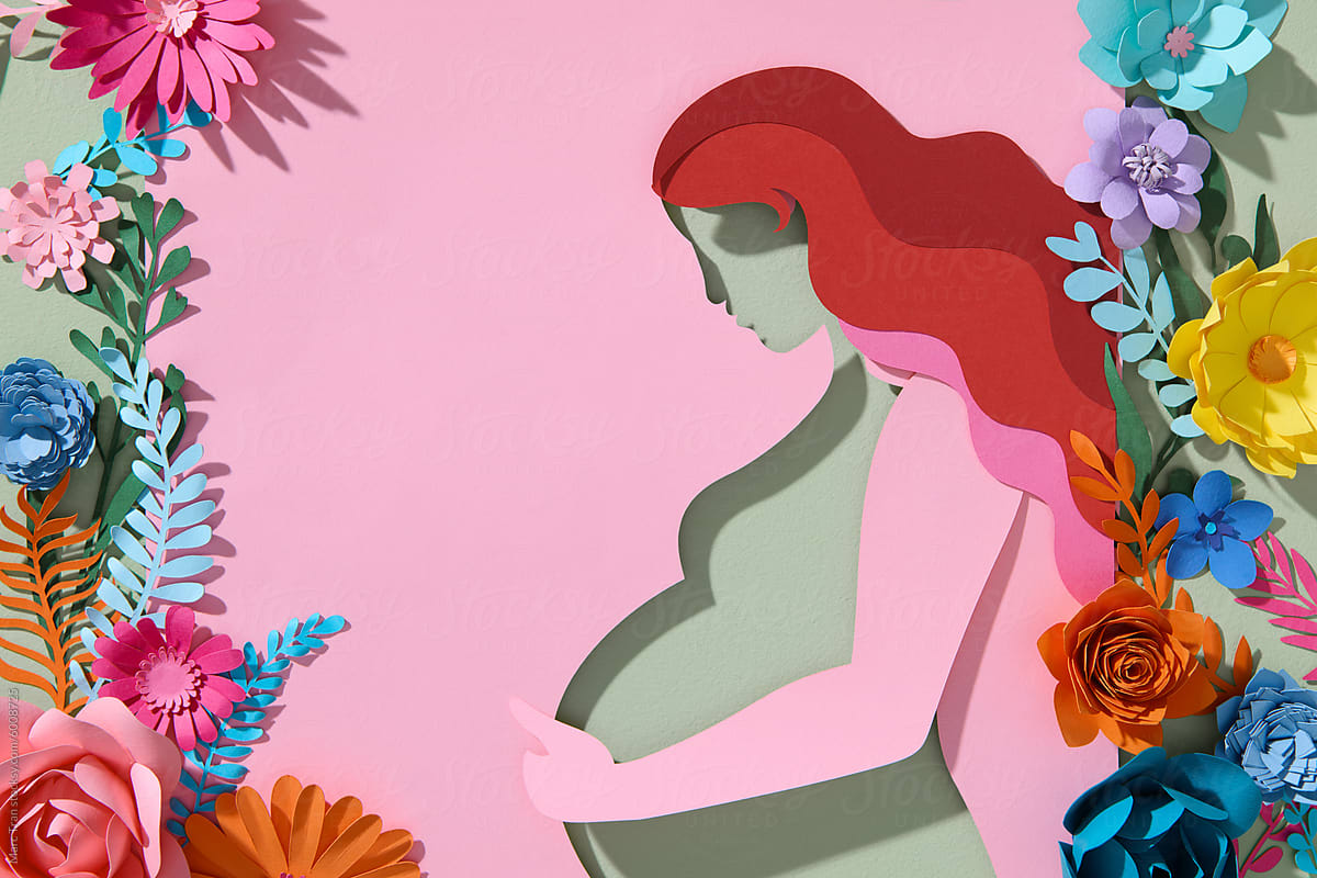 A pregnant woman hugs her stomach on a pink background