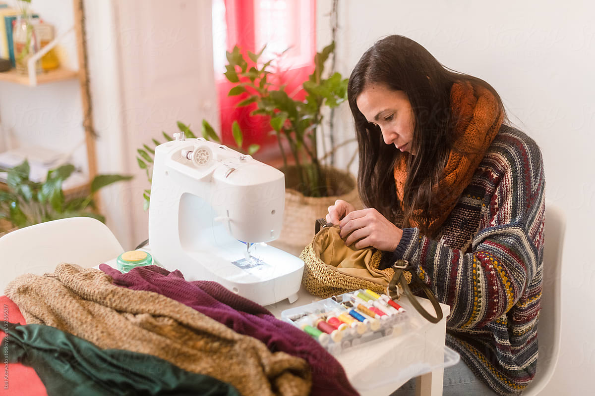 Woman sewing clothes and handbag at home