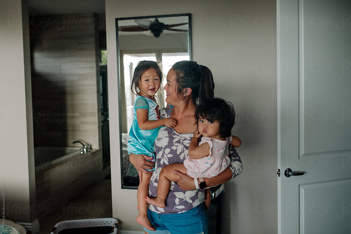 Asian-American mom holding daughters