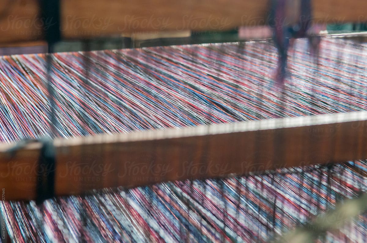 Cotton threads passing through a traditional wooden loom machine