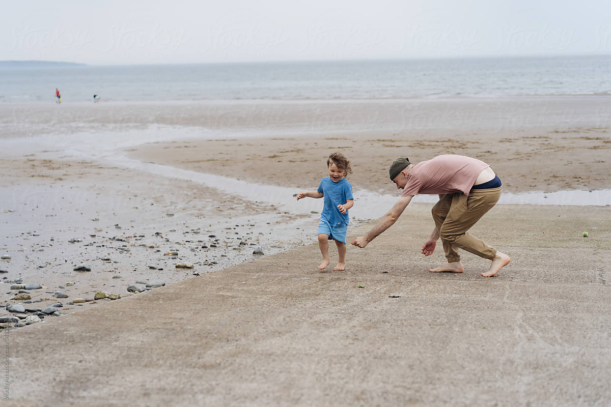 Man playing with little boy on the beach
