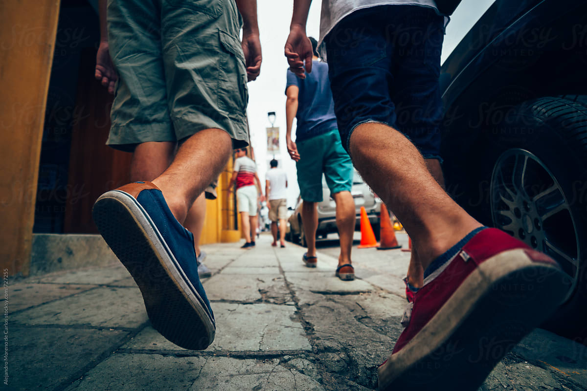 Low angle shot of the feet of some men friends walking down a street
