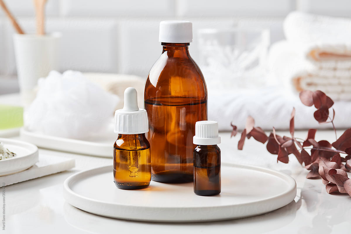 Essential oils in bottles on white plate.