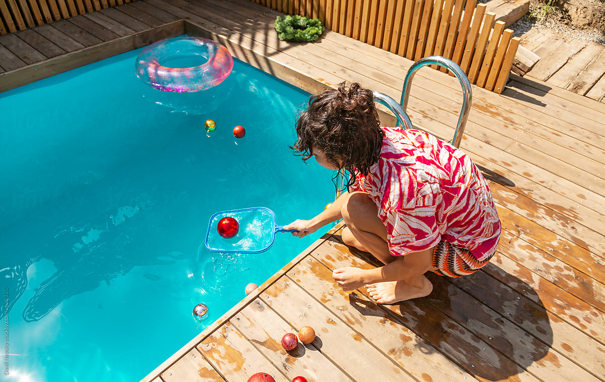 Woman picking baubles from pool water