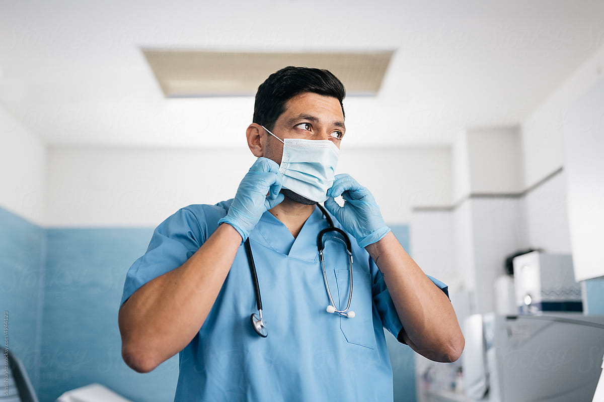 Portrait of doctor putting on protective mask