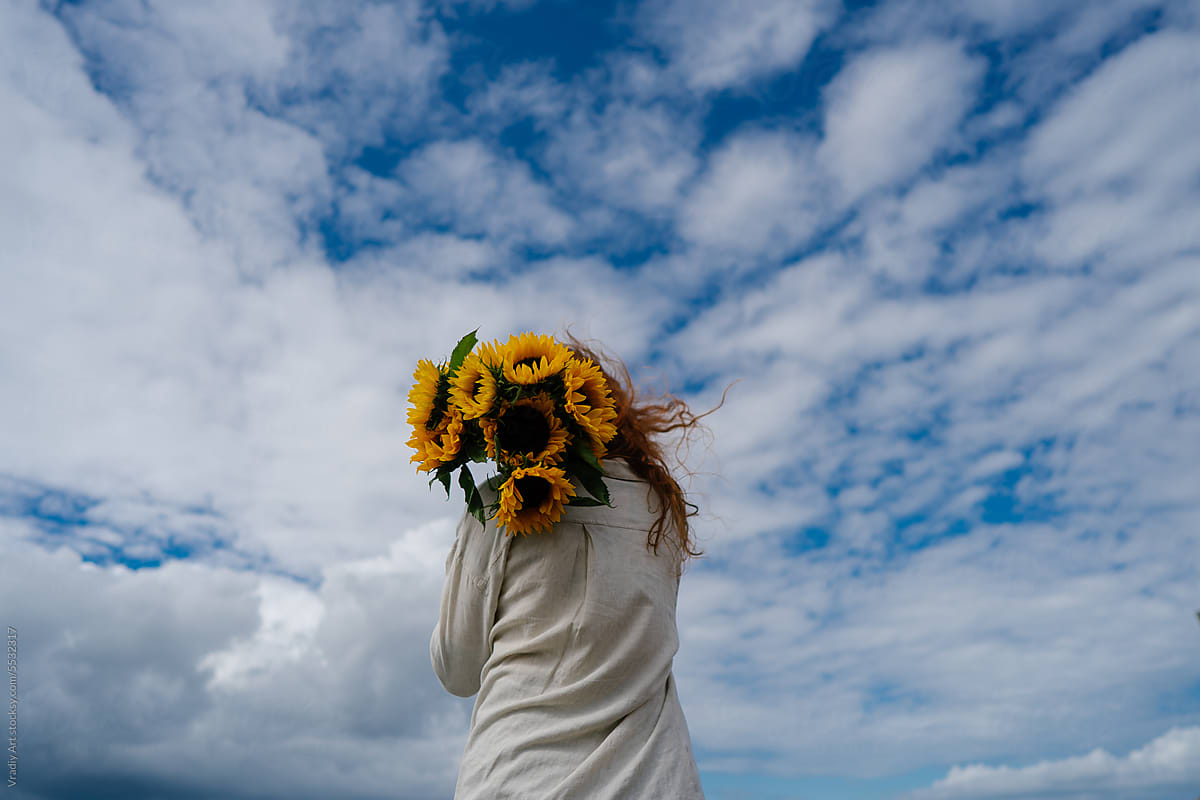 Woman with bouquet of fresh sunflowers