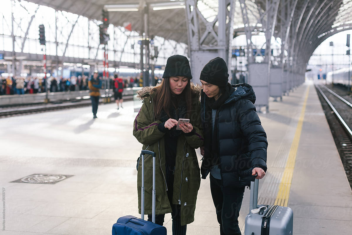 Asian friends waiting for a train on a train station