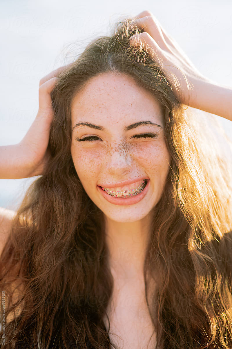 Closeup portrait of playful teenage freckled girl with teeth braces