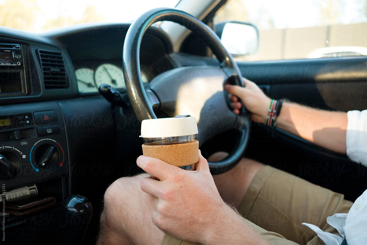 Coffee in drivers hand on a roadtrip