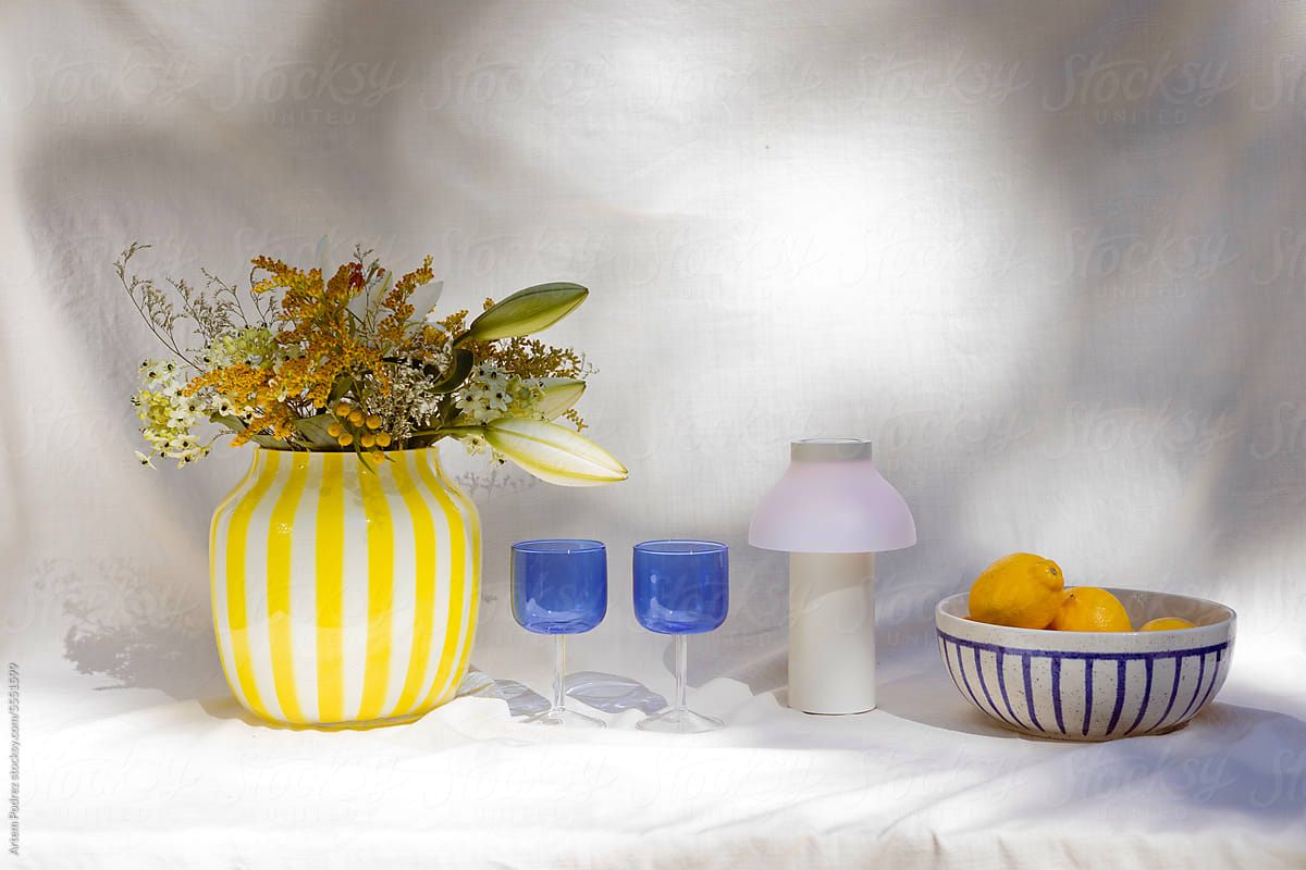 Stylish summer still life from a vase with flowers and blue glasses