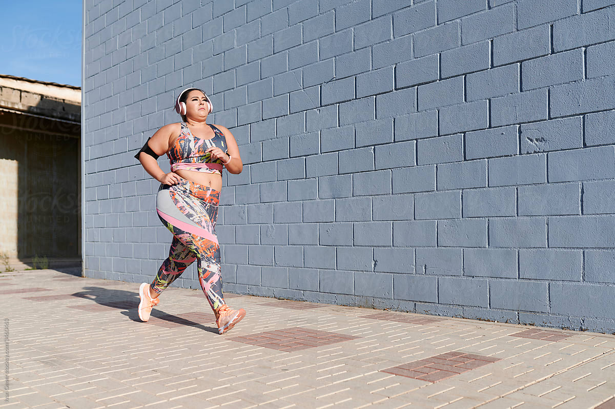 Full-figured woman jogging to music