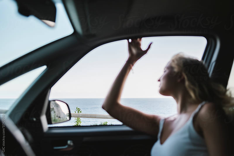 Young happy woman traveling by car