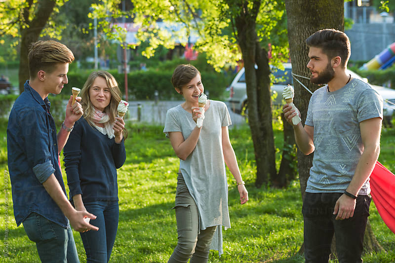 Group of friends having fun and eating ice cream outdoor