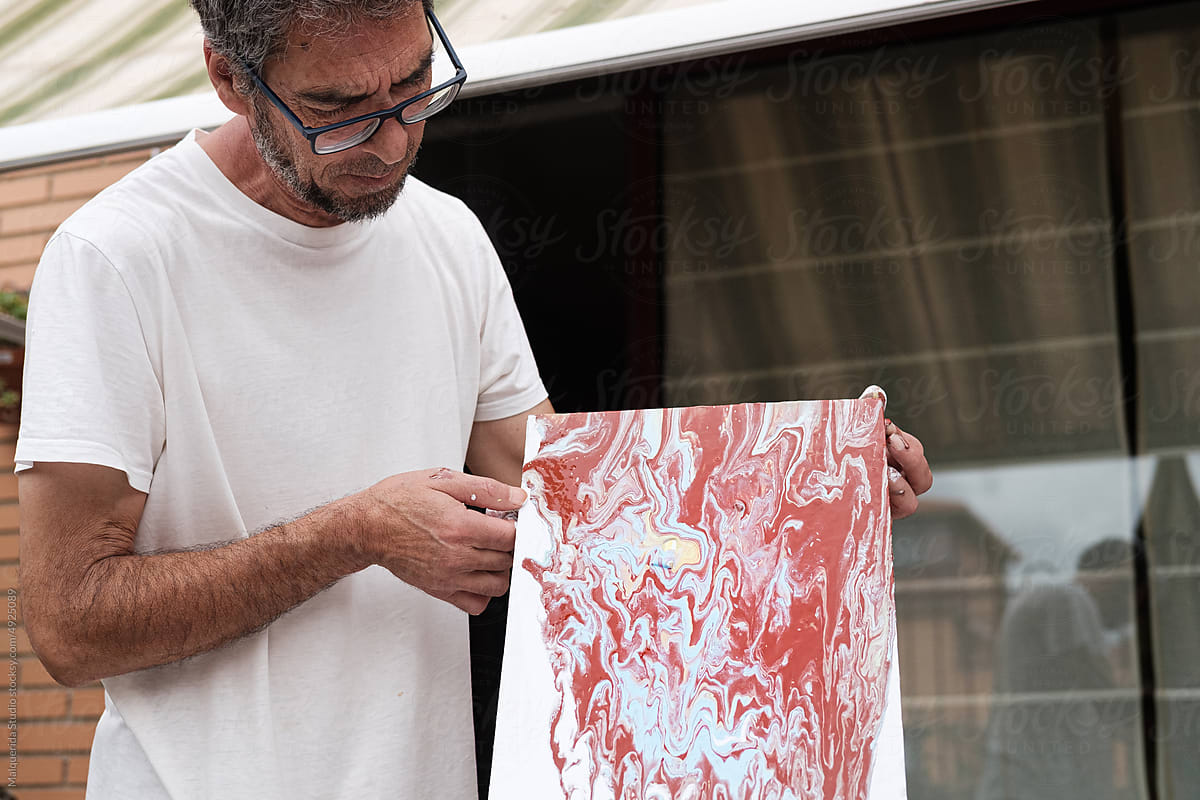 Artist man pouring colorful paint