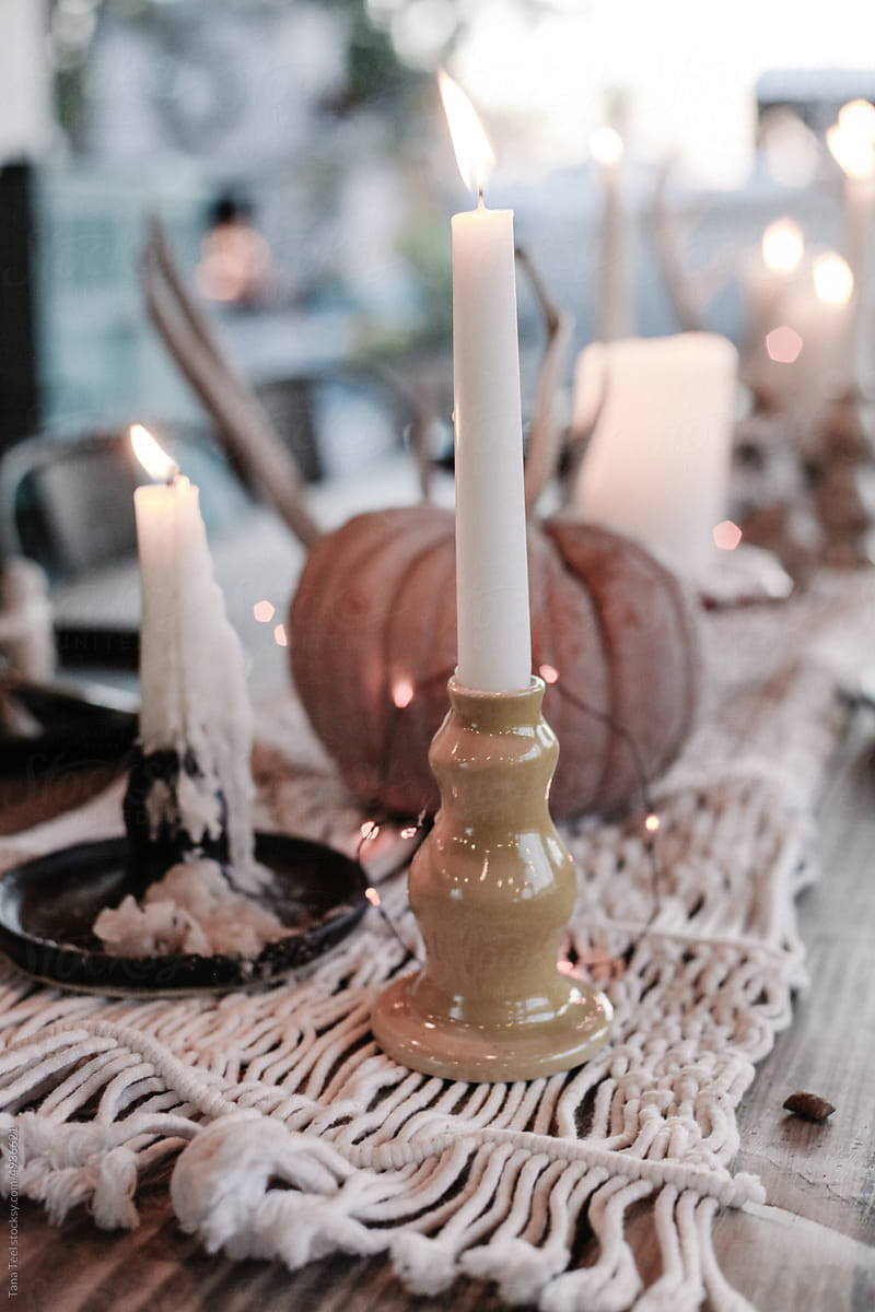 lighted candles in hand made pottery on fall table