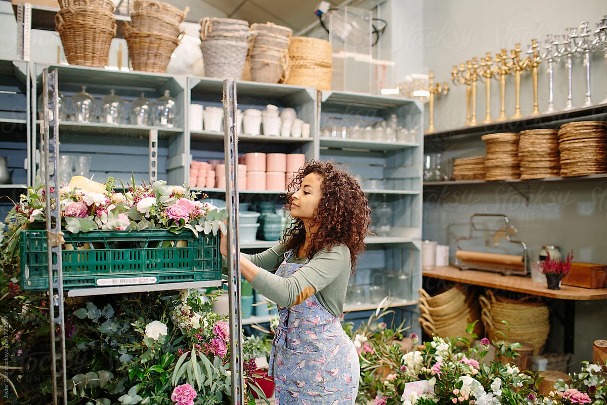 Woman working with fresh flowers in shop