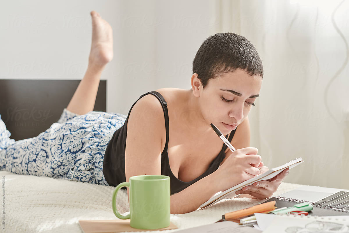 Pensive millennial woman taking notes in journal