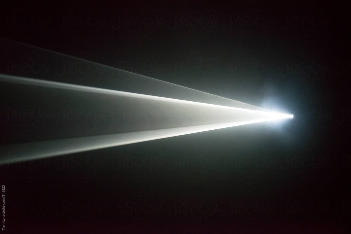 Illuminated beam of light from a projector by Trent Lanz - Stocksy ...