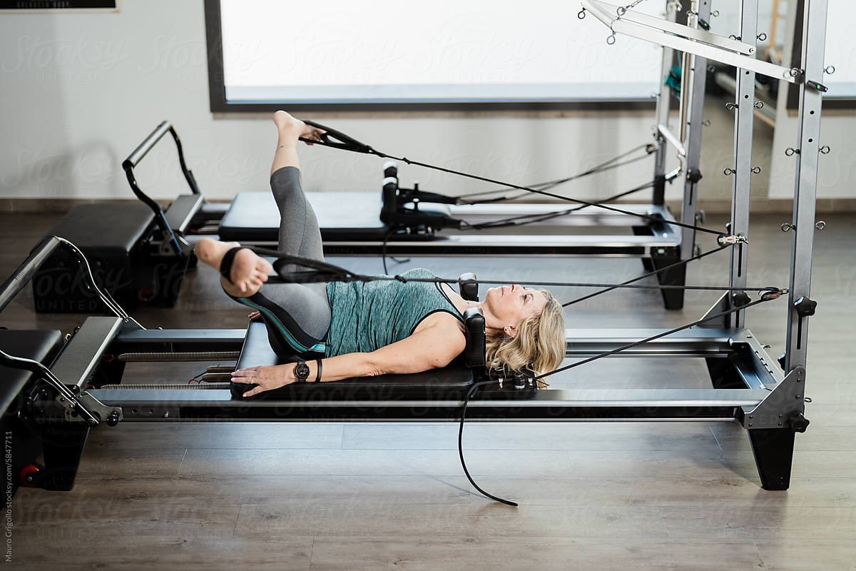 Woman doing pilates exercises in a gym