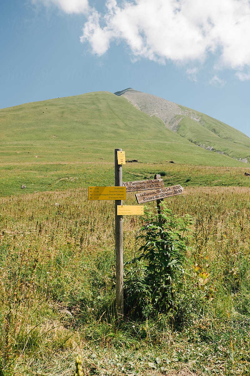 the top of a mountain in the Alps, sign posts indicating the destination.