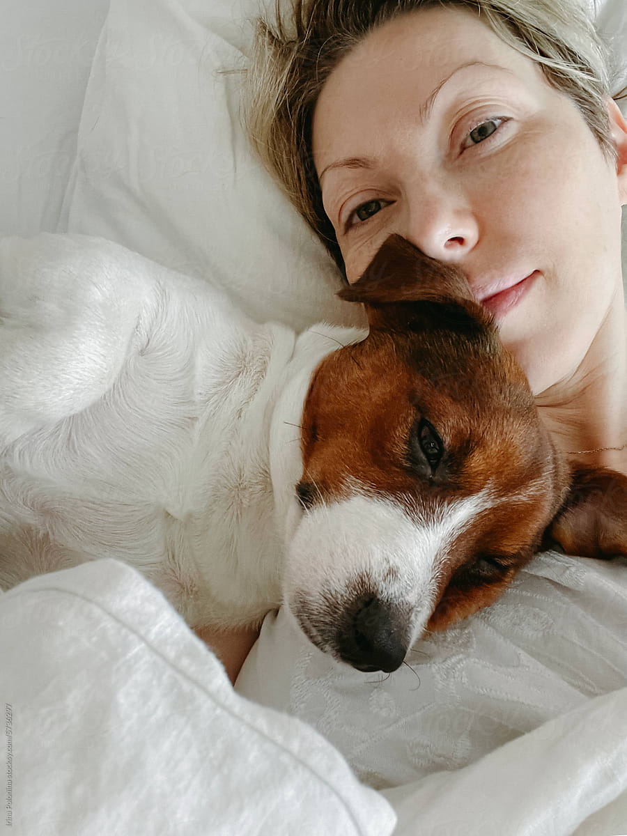 Selfie with cute pet on bed.