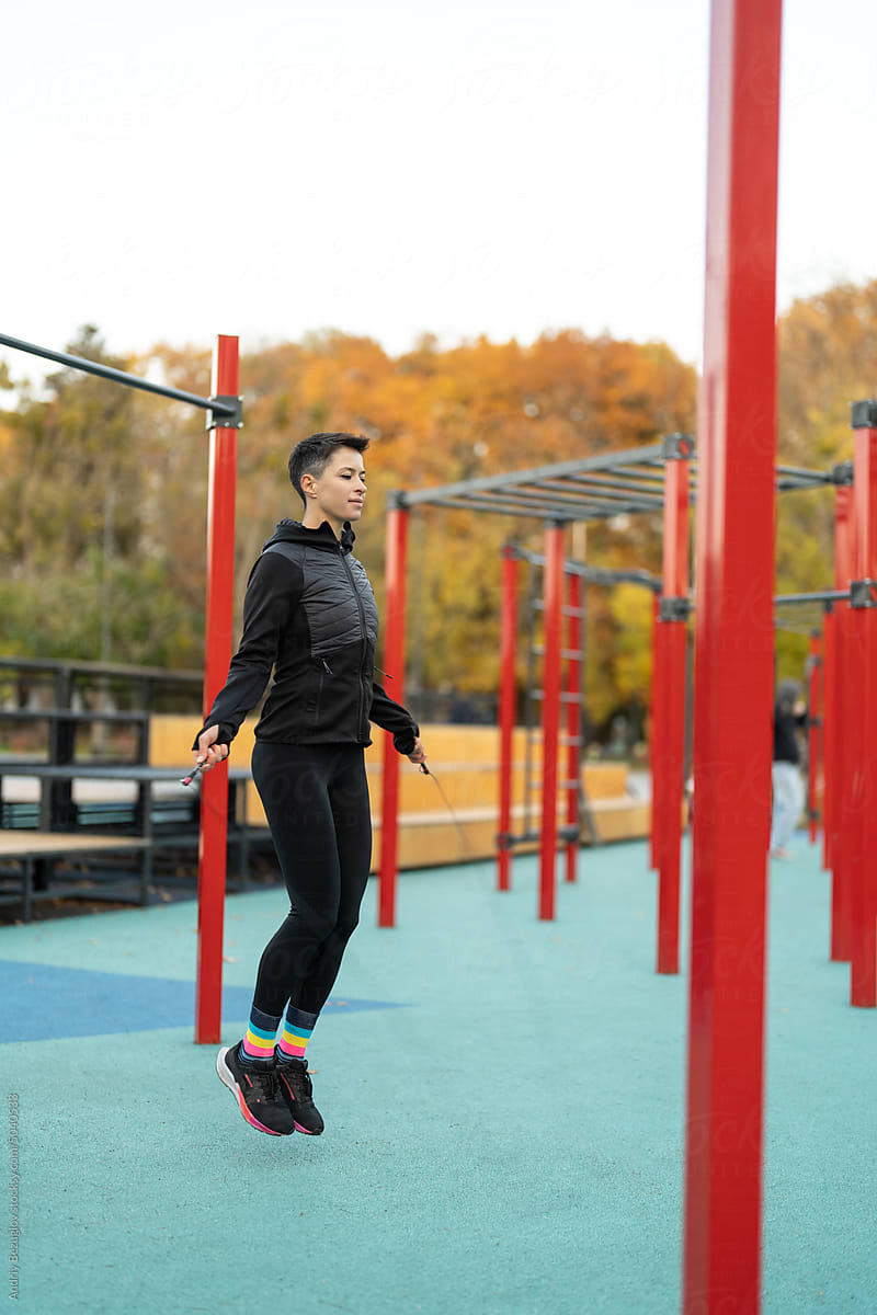 Athletic woman training at fitness playground outdoors