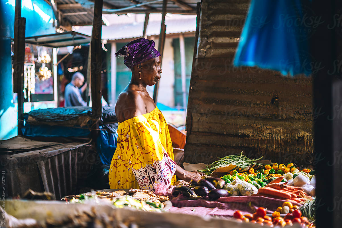 Mature African seller behind stall