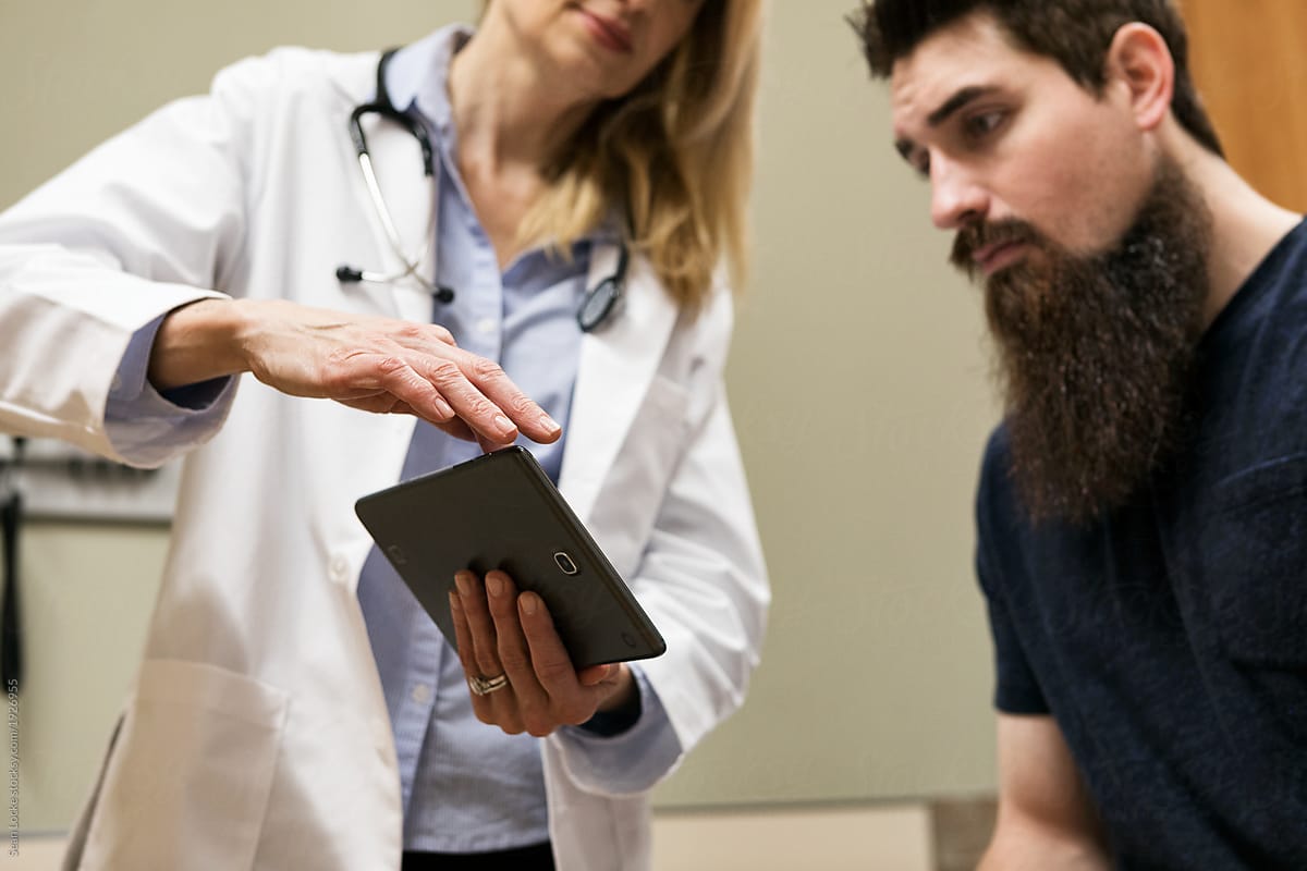 Clinic: Doctor Discussing Test Results On Tablet With Patient