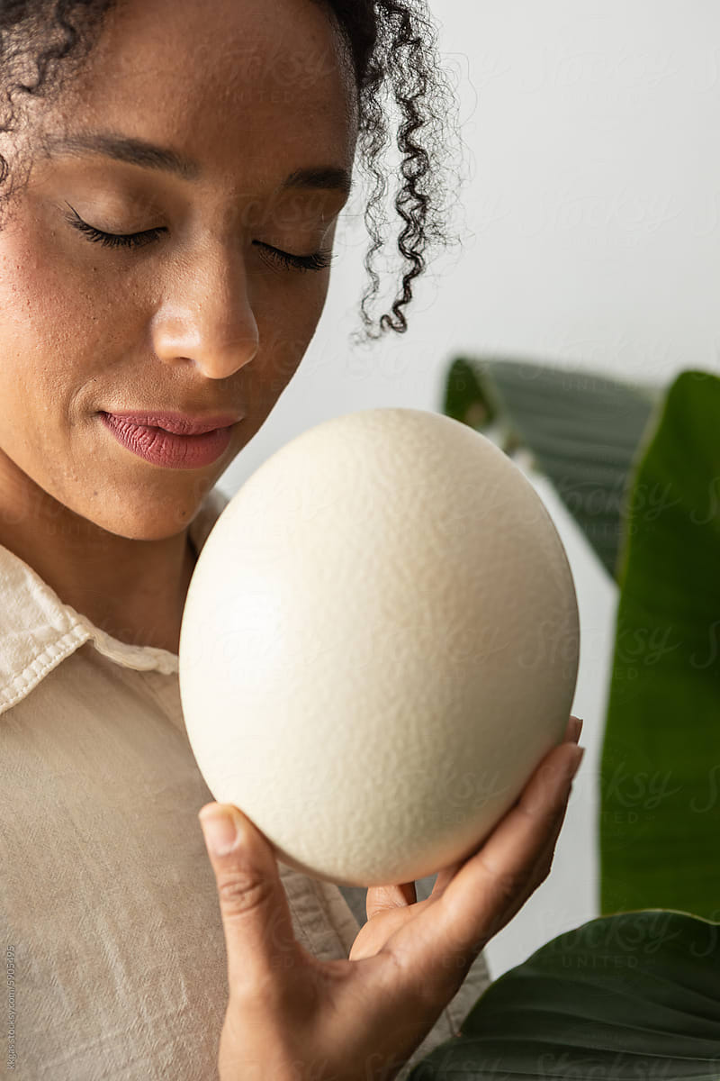Woman with eyes closed, and ostrich egg