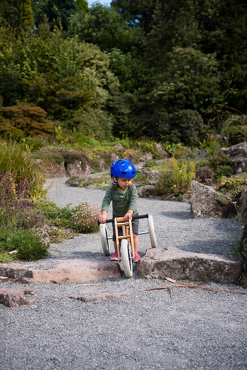 Boy riding his tri-cycle over some rocks, New Zealand.