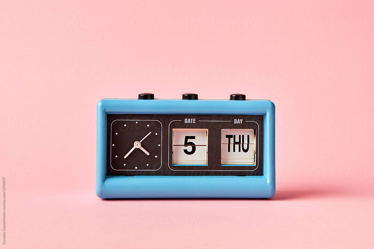 Flip clock with date calendar on a background, color of the year 2019 Living Coral pantone. Day Thusday, date 5, time is twenty two to five.