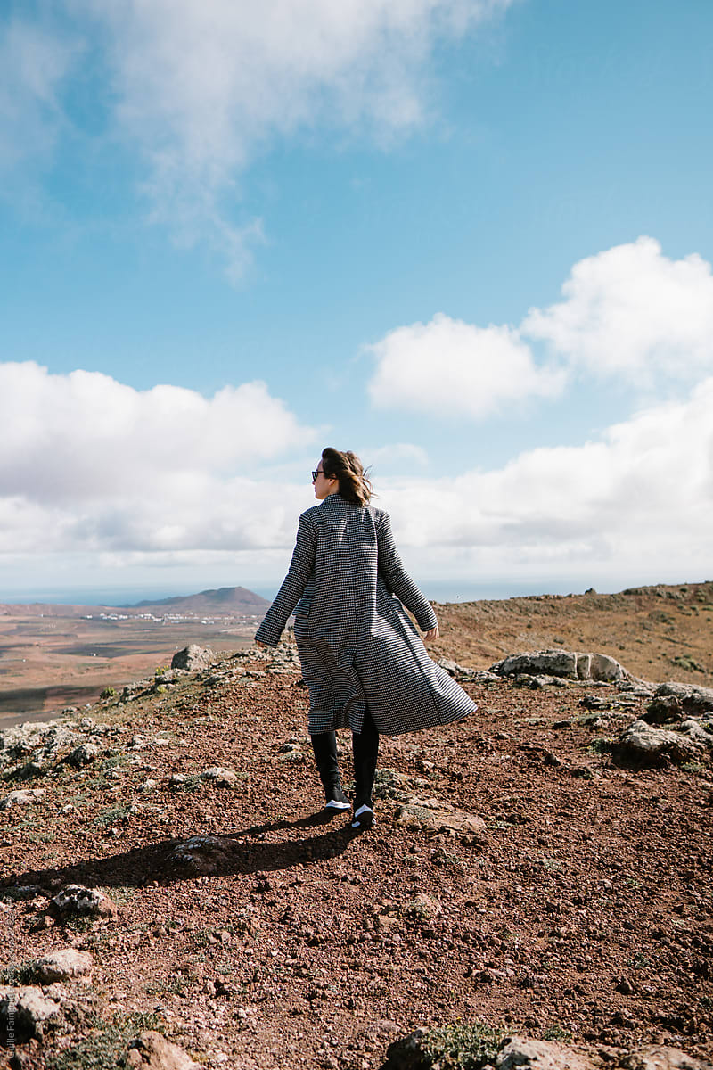 Woman in coat standing in picturesque valley
