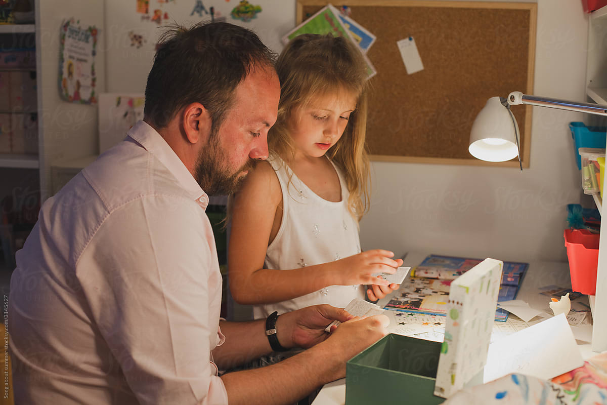 father playing board games with daughter in the evening