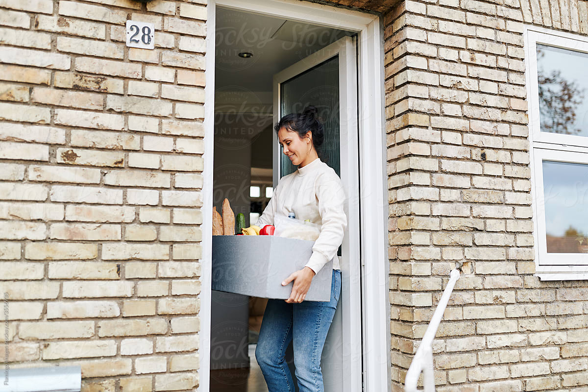 Woman taking a food delivery indoors