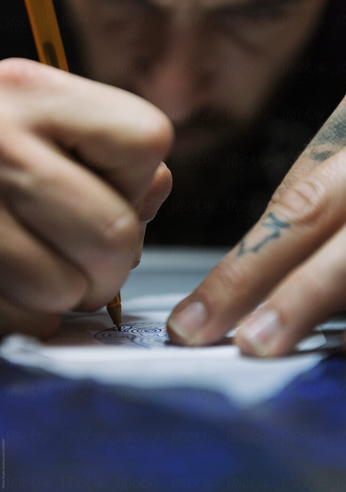 Close-up tattooist sketching