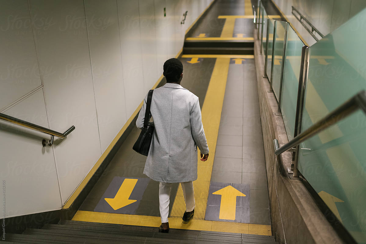 Businessman walking downstairs in underground corridor