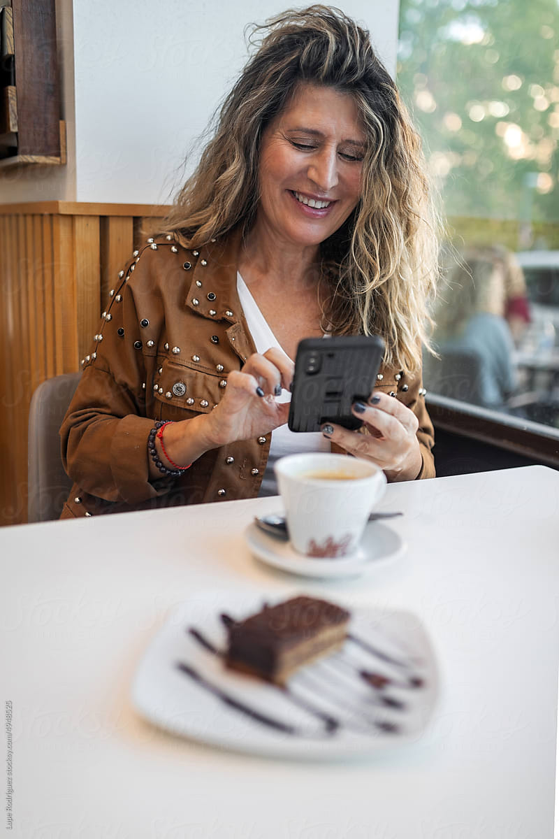 mature woman with mobile phone in coffee shop
