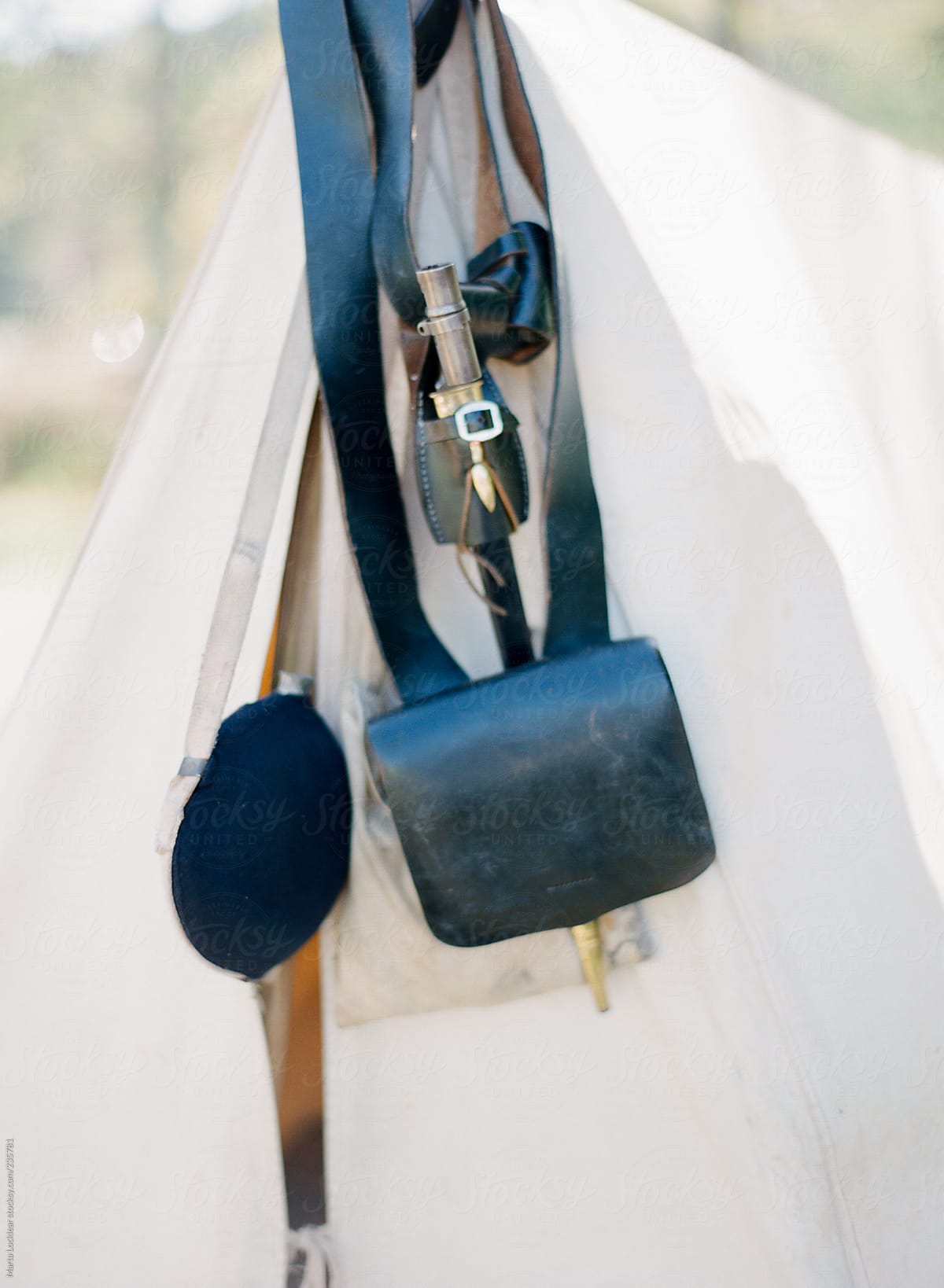 Old war camping gear hanging from a white tent