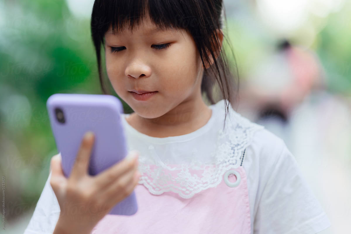 Little girl uses mobile phone navigation on the street