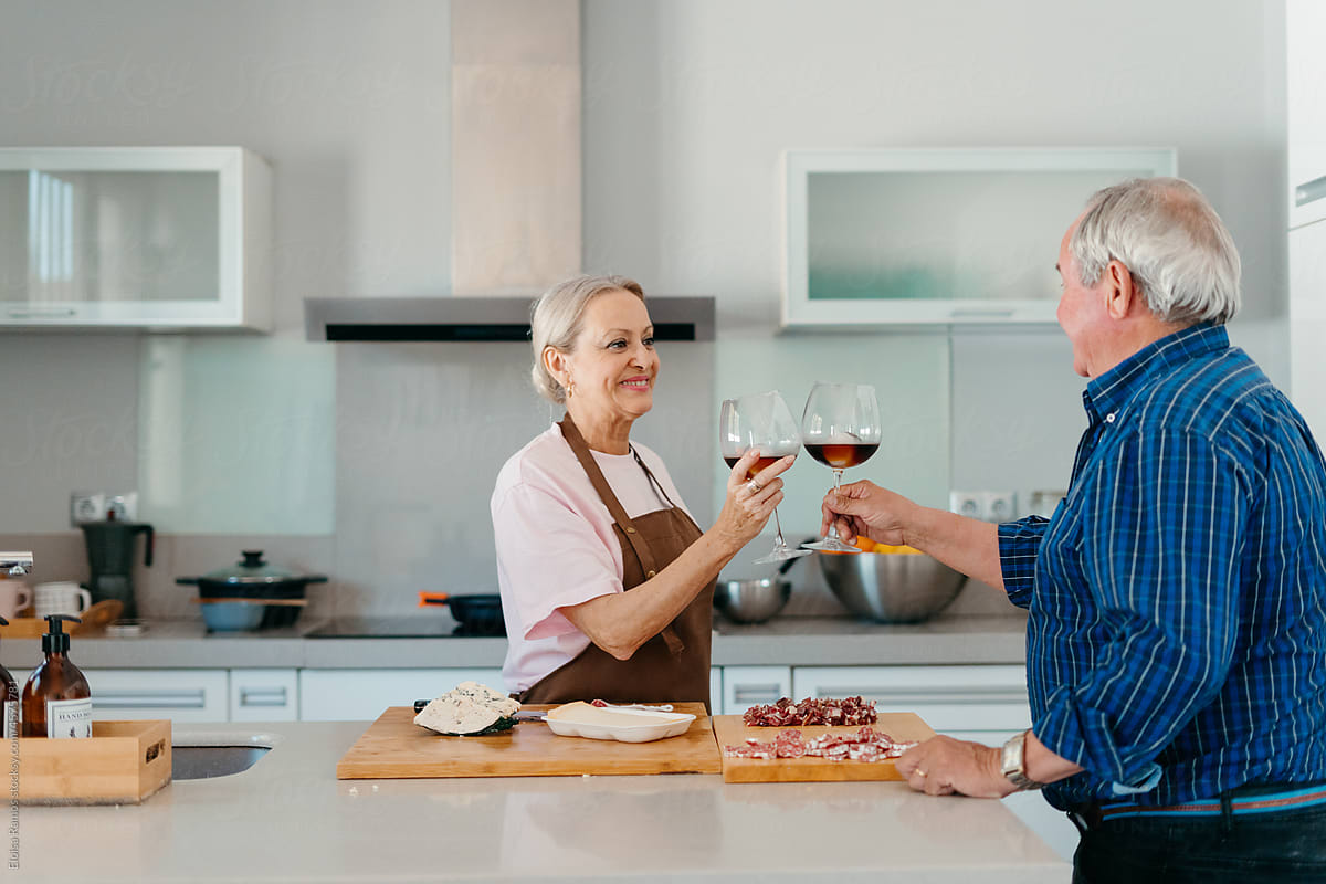 Mature marriage drinking wine in kitchen