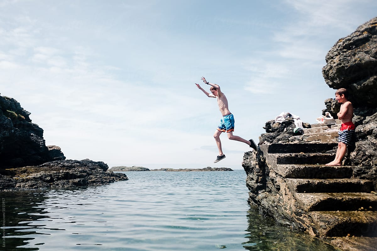 teen boy jumping in the sea