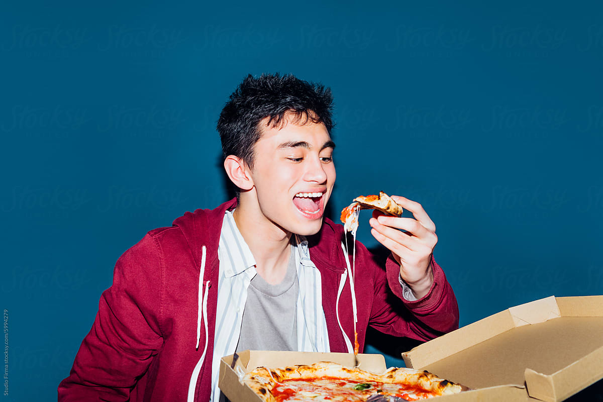 Young man eating pizza